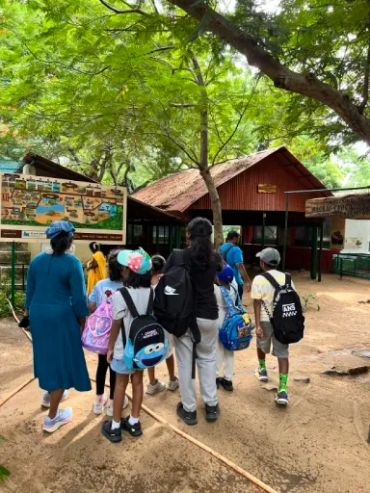 Group of children with backpacks walking outdoors.