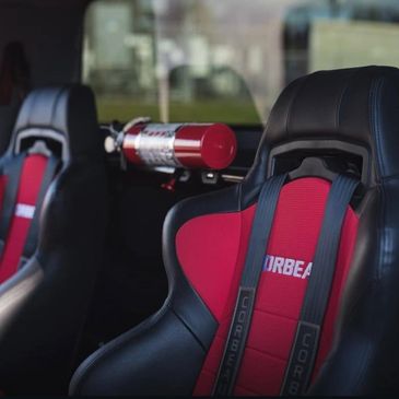 Racing seats with red and black design inside a car.