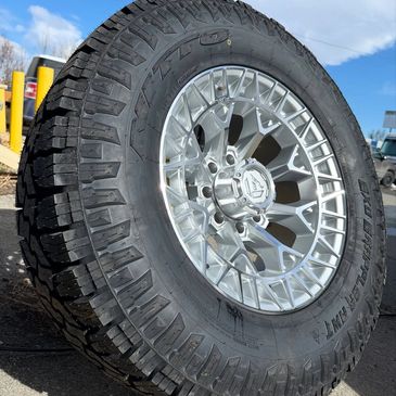 Close-up of a rugged Toyo Open Country tire with a shiny alloy rim.