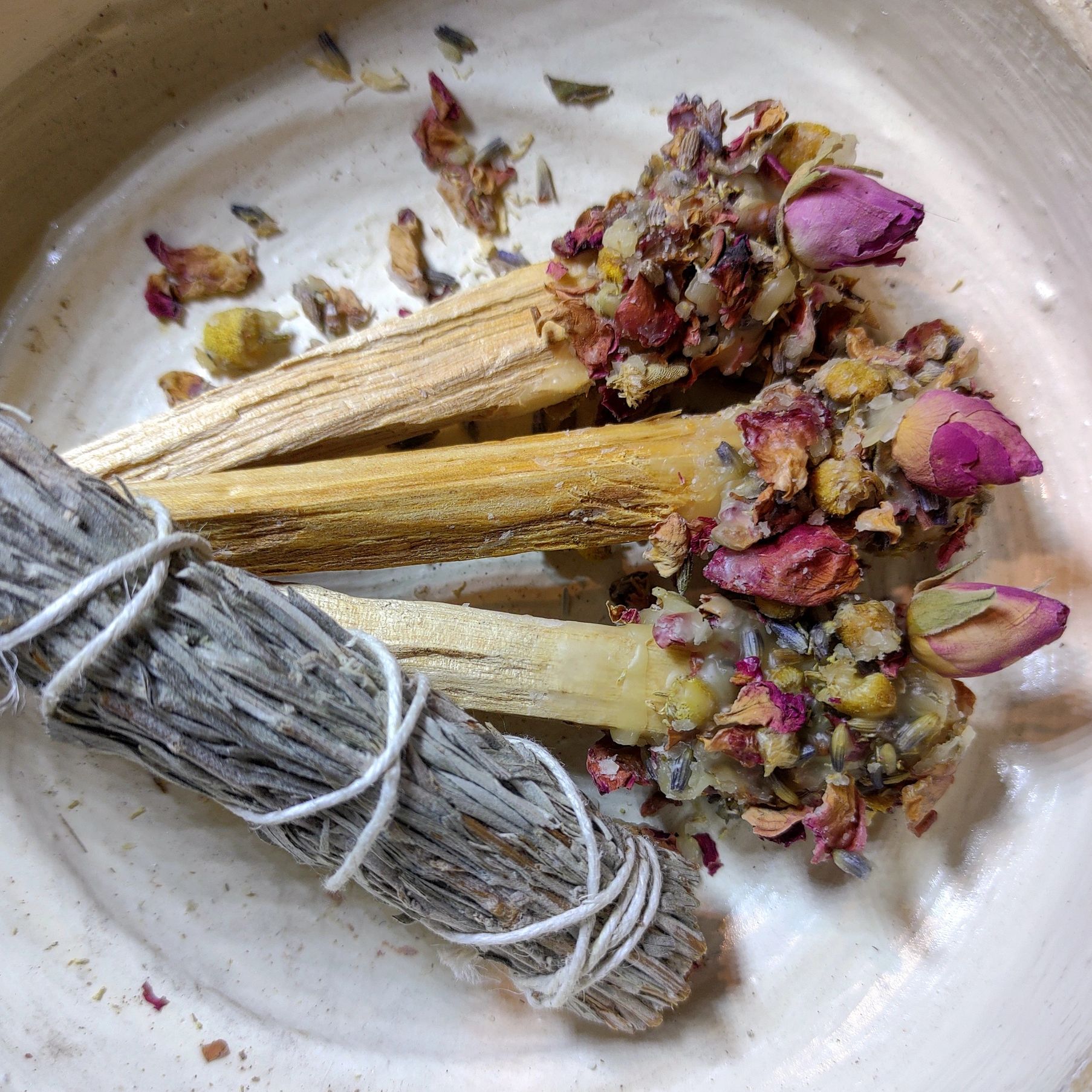 sage and palo santo smudge sticks, palo adorned with rose, chamomile, and lavender buds