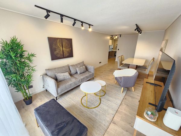 Sala moderna con sofá gris y decoración minimalista.