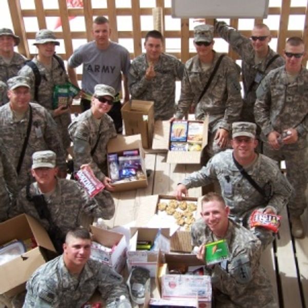 Group of soldiers with care packages and snacks.