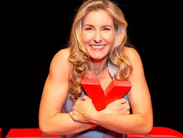 Smiling woman hugging a red 'X' symbol.
