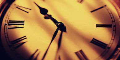 Clock face with Roman numerals in shadow.