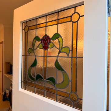 Restored Art Nouveau leadlight window in a repaired timber sash, heritage carpentry Melbourne