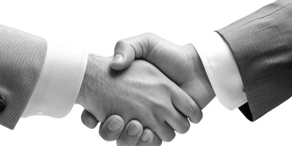 Two businessmen shaking hands in a formal agreement.