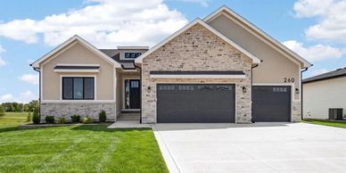 Modern suburban house with stone facade and three-car garage.