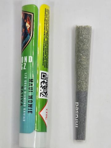 Pre-rolled cannabis joint next to its green and yellow packaging labeled Maui Wowie.