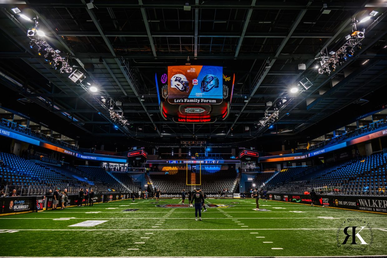 Indoor football stadium with scoreboard showing Arizona Rattlers vs. Massachusetts Pirates.