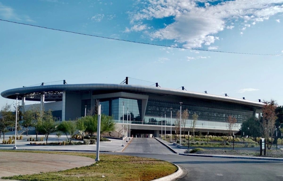 Modern architectural building with a curved roof under a blue sky.