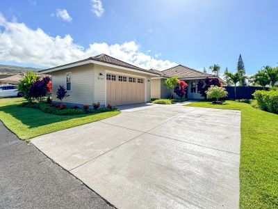 Single-story house with a spacious driveway and well-kept lawn.