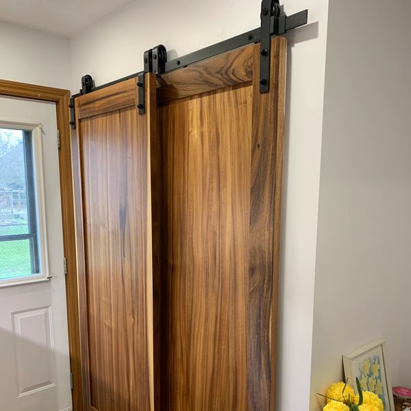 Two wooden sliding barn doors on a black metal track.