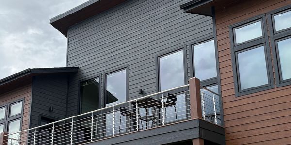 Modern house with balcony and outdoor seating.