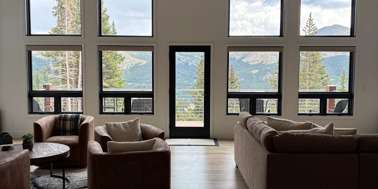 Cozy living room with large windows showcasing mountain views.