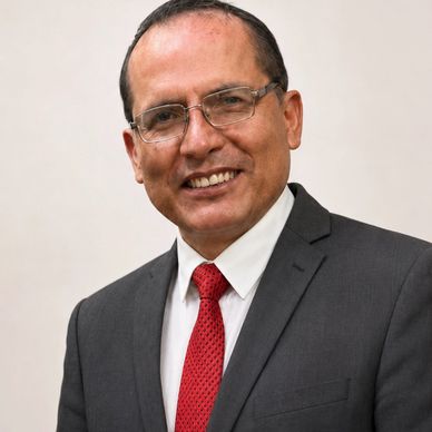 Smiling man in glasses wearing a suit and red tie.