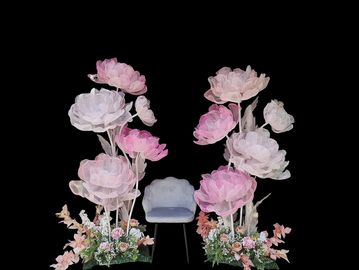A pastel floral arrangement with a blue chair against a black background.