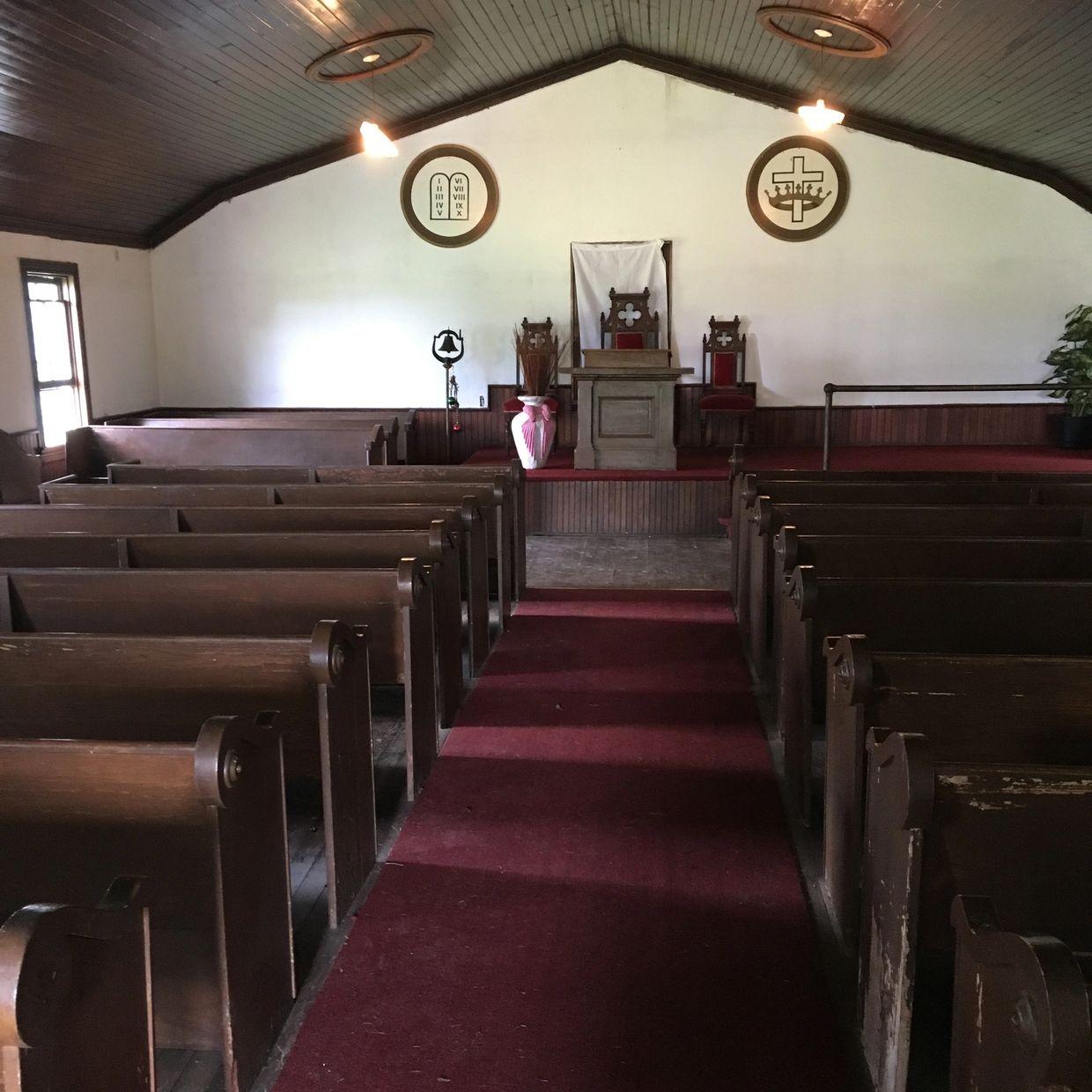 Empty church interior with wooden pews and red carpet.