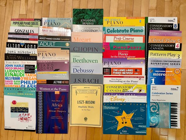 Assortment of piano music books and sheet music.