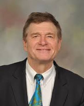 Smiling man in a suit and colorful tie.