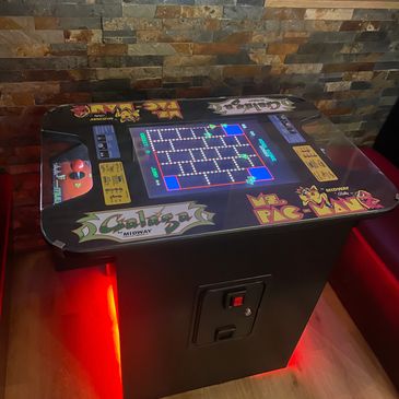 Classic arcade cocktail table displaying Ms. Pac-Man game.
