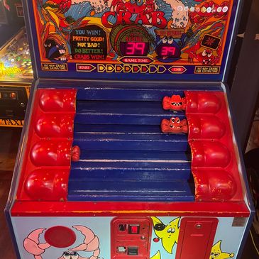 Vintage arcade game called King Crab with red crab paddle pieces.
