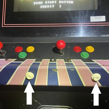 Arcade game control panel with damaged pink keys and colorful buttons.