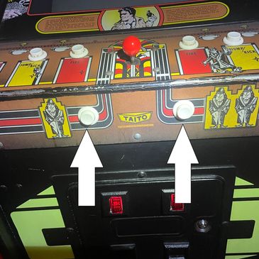 Vintage Taito arcade game control panel with joystick and buttons.