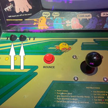 Close-up of a vintage arcade game's control panel with joystick and buttons.