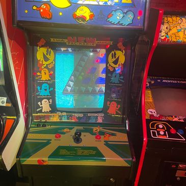 Classic Pac-Man arcade game machine with colorful characters.