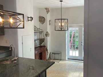 Modern kitchen with black countertops and unique pendant lighting.