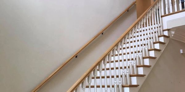 Fresh stairwell repaint with crisp white trim and natural wood accents. LG Painting + C