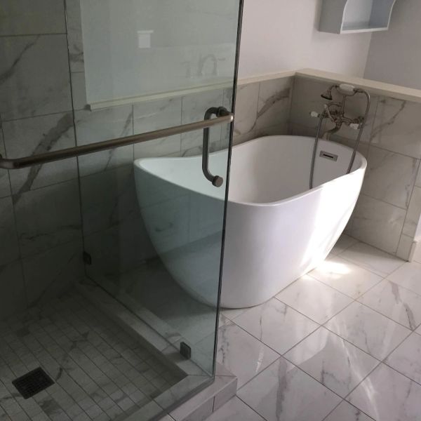 Luxury bathroom remodel completed in Charleston, SC featuring a freestanding soaking tub, custom til