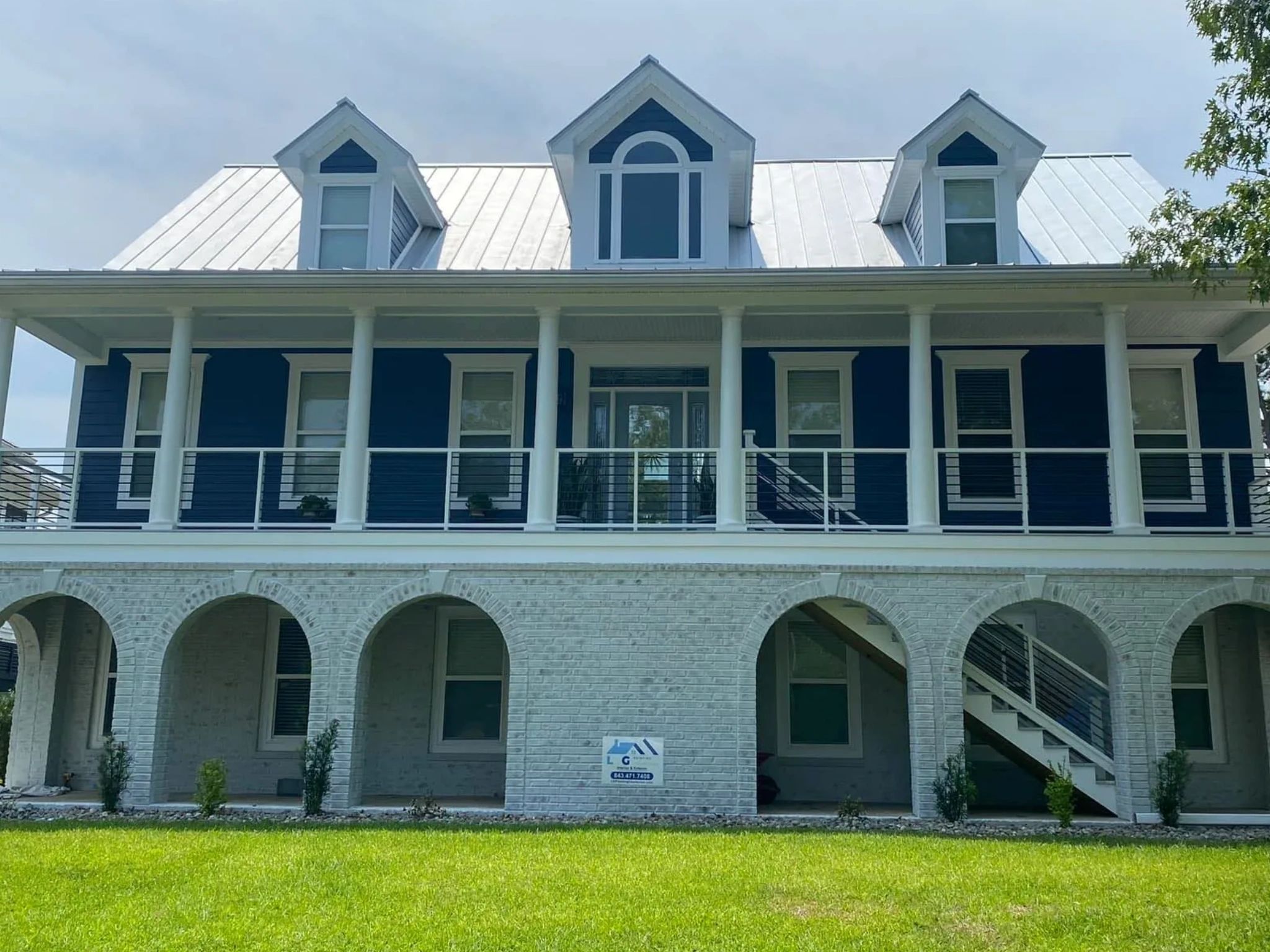 Blue and white house with columns and arches.