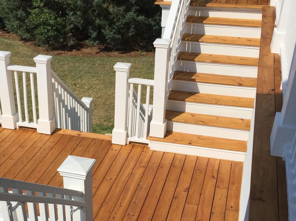 Finished wood deck with white railings and stairs.