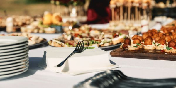 A table set with plates, utensils, and appetizers for an event.