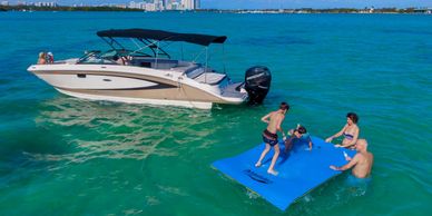 people on vacation in the water with a boat in Miami FL
