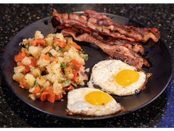 American breakfast 2 eggs, 2 strips of bacon and seasoned breakfast potatoes