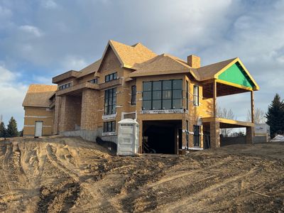 New house under construction on a dirt lot.