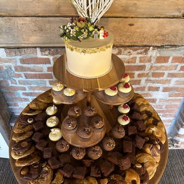 Elegant multi-tiered dessert display with cake, cupcakes, brownies, and cookies.