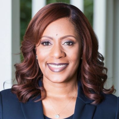 Professional woman with styled hair and a confident smile.