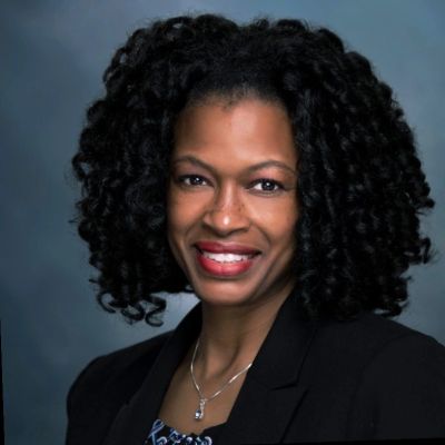 Professional woman smiling in business attire.