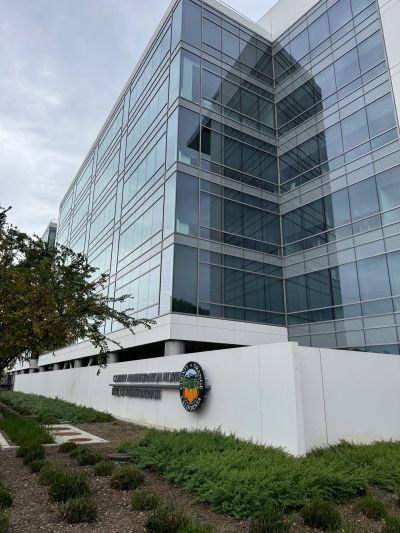 Modern glass office building with a clear sky.