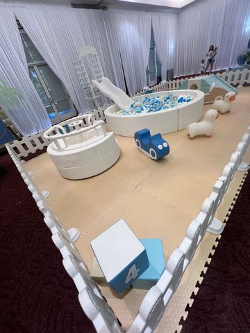 Indoor play area with ball pit, slide, and toys for children.
