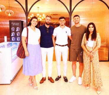 Group of five people posing indoors.