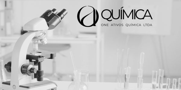 Microscope and lab glassware in a chemistry lab with company logo.