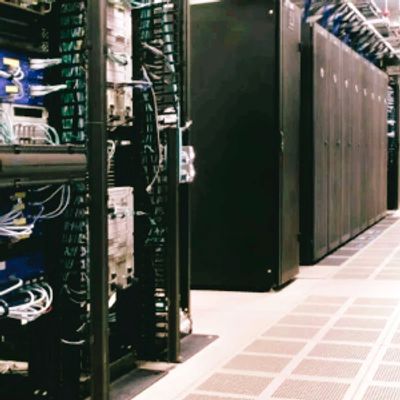 Data center server racks with cabling and cooling infrastructure.