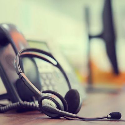 Headset resting on a desk phone.