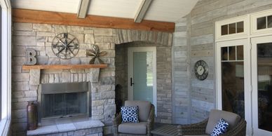 Screen porch with stone fireplance with custom shiplap wall