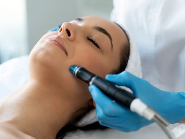 Smiling woman enjoying a facial treatment. Counter-Clock Skin Clinic in Milton.