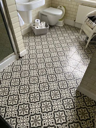 Vintage-style tiled bathroom floor with monochrome patterns.